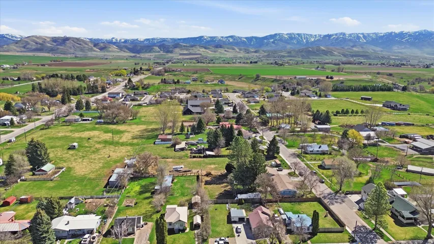Aerial view of property and surrounding area featuring nearby suburban area and rural landscape