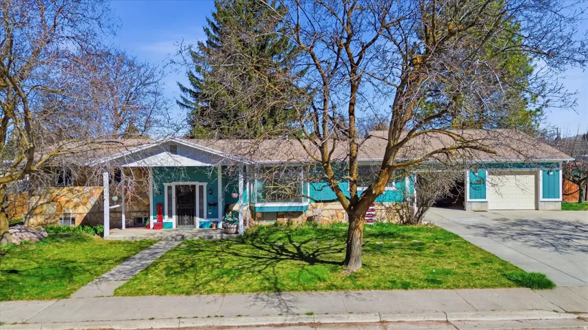 View of front of house with driveway, a front lawn, and an attached garage
