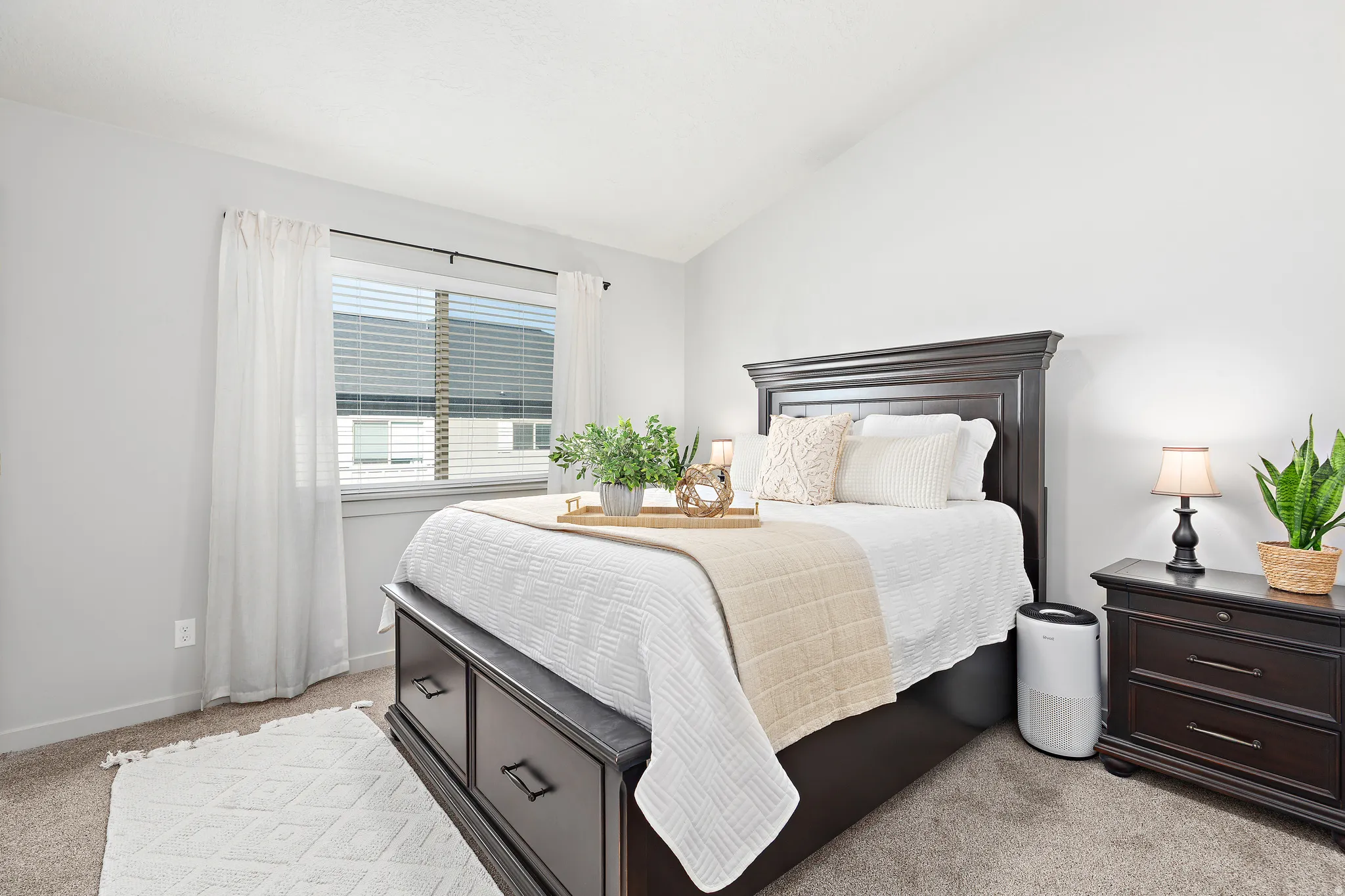 Bedroom with light colored carpet and vaulted ceiling
