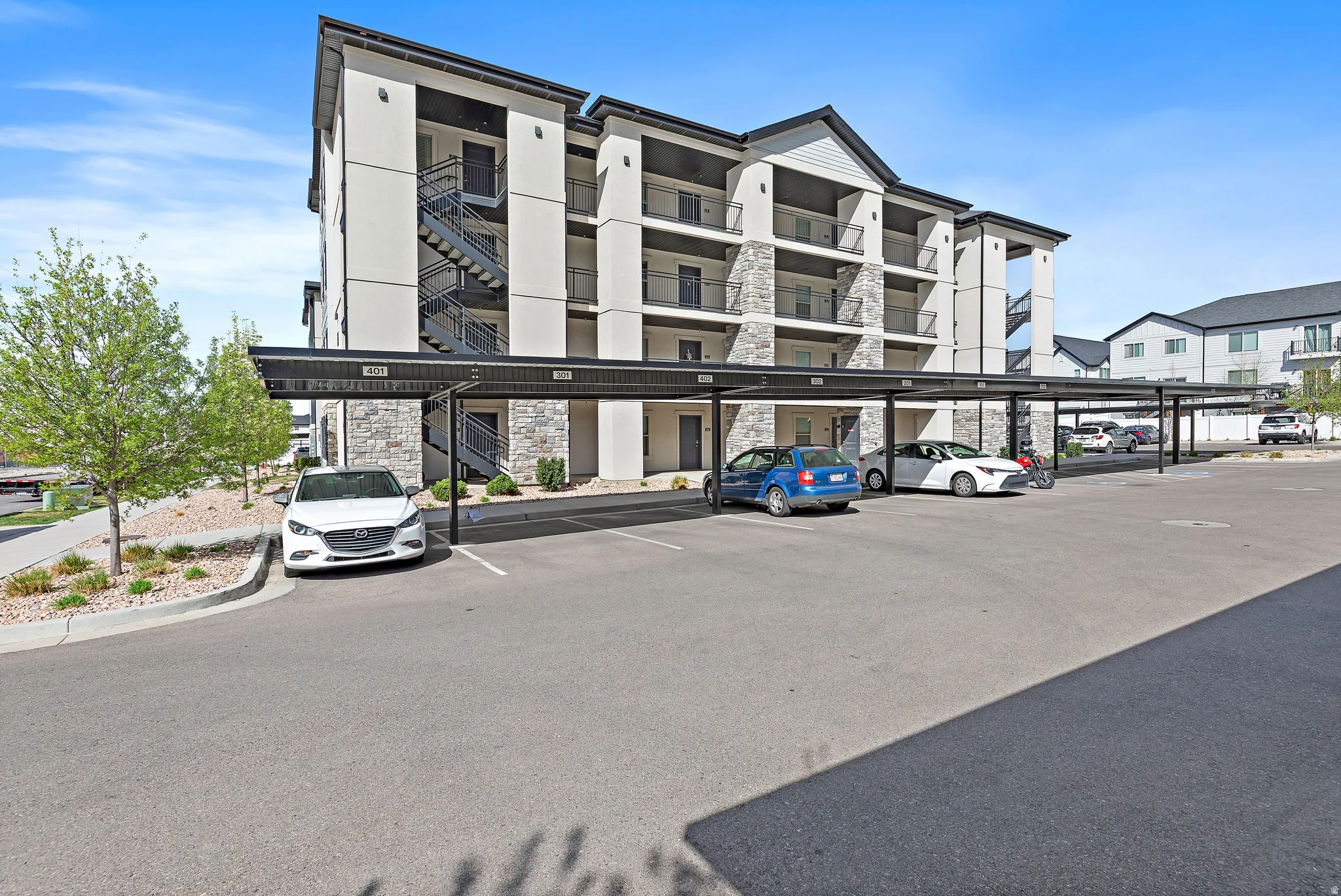 View of apartment building / complex featuring covered parking