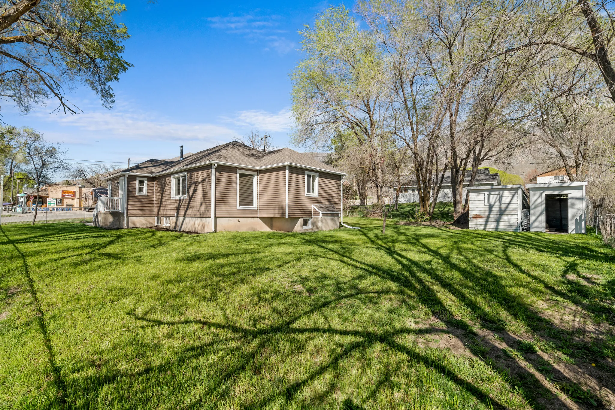 View of home's exterior with a lawn and an outbuilding