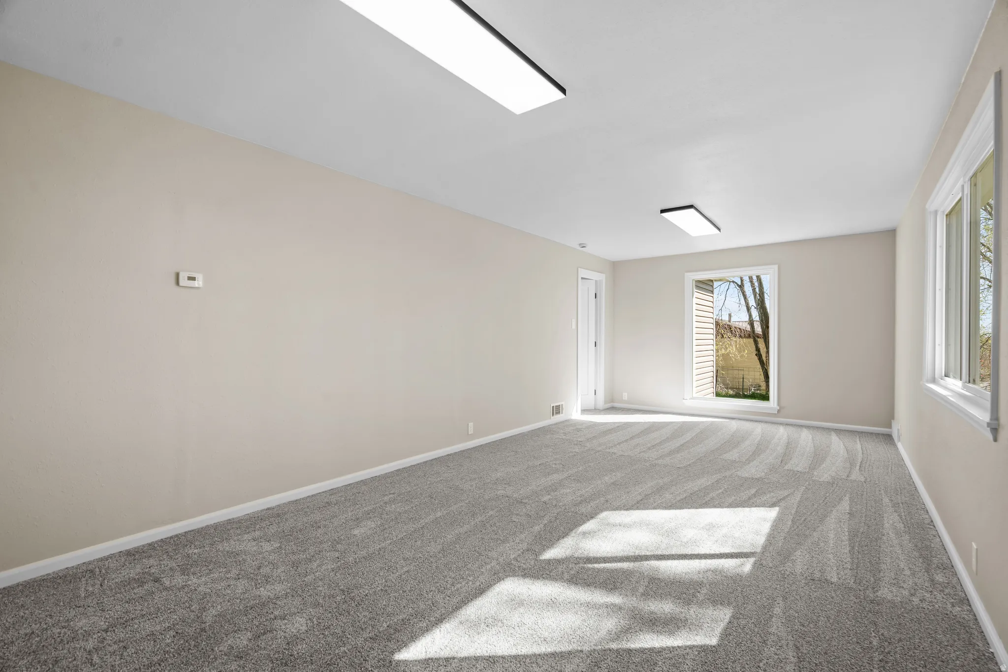 Carpeted spare room with baseboards