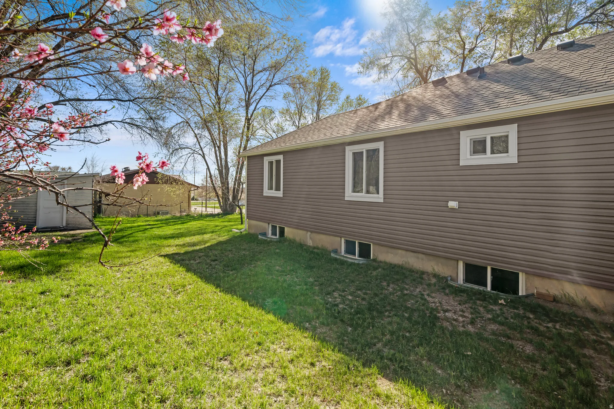 View of home's exterior with a lawn and roof with shingles