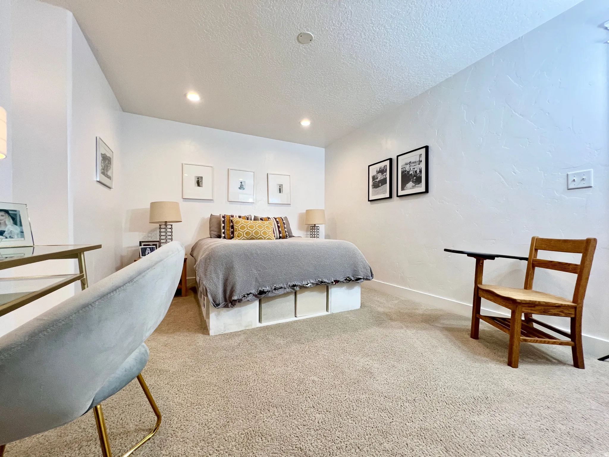 Bedroom with light colored carpet, a textured ceiling, recessed lighting, and a textured wall
