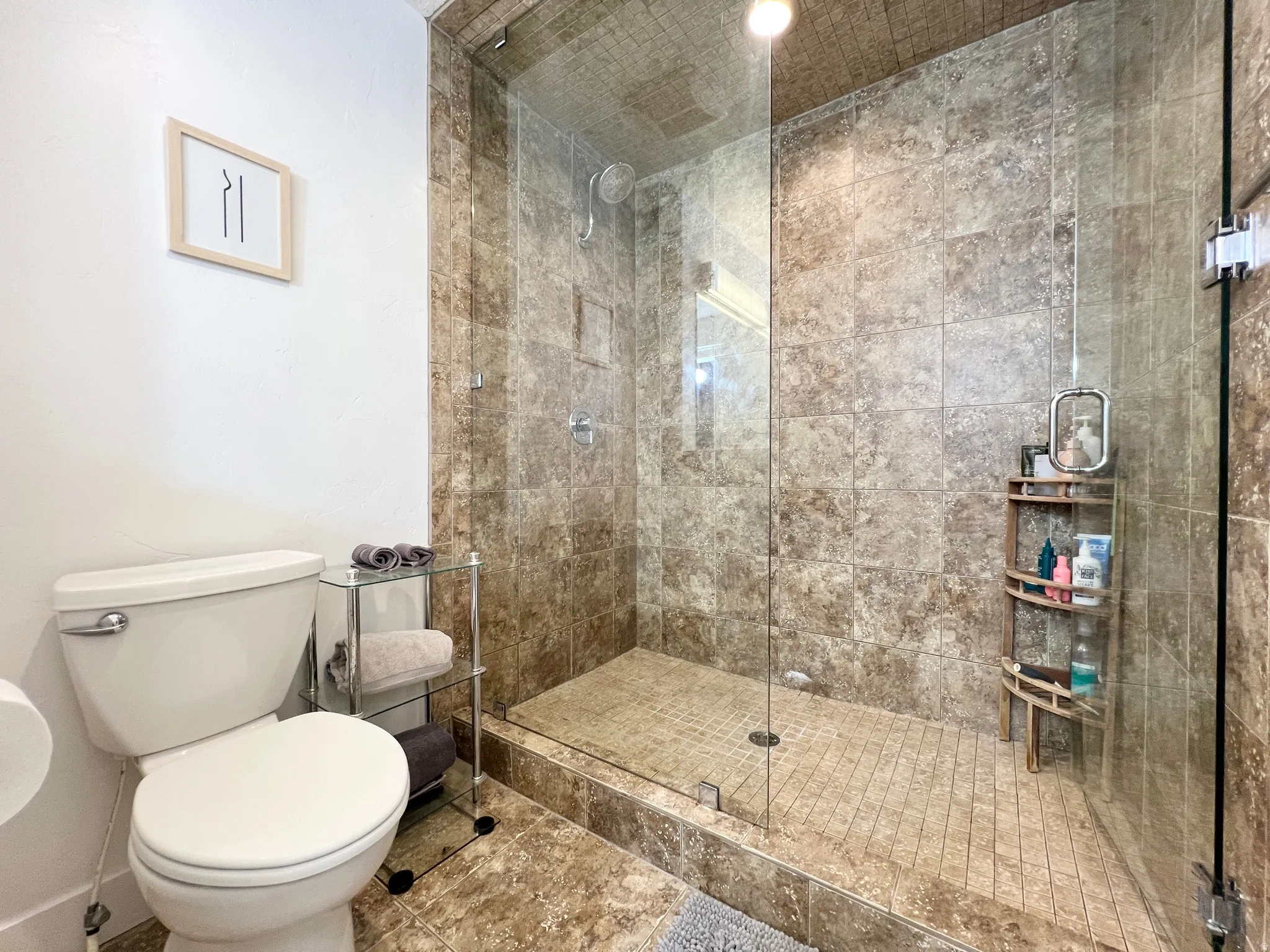 Bathroom featuring toilet and a stall shower