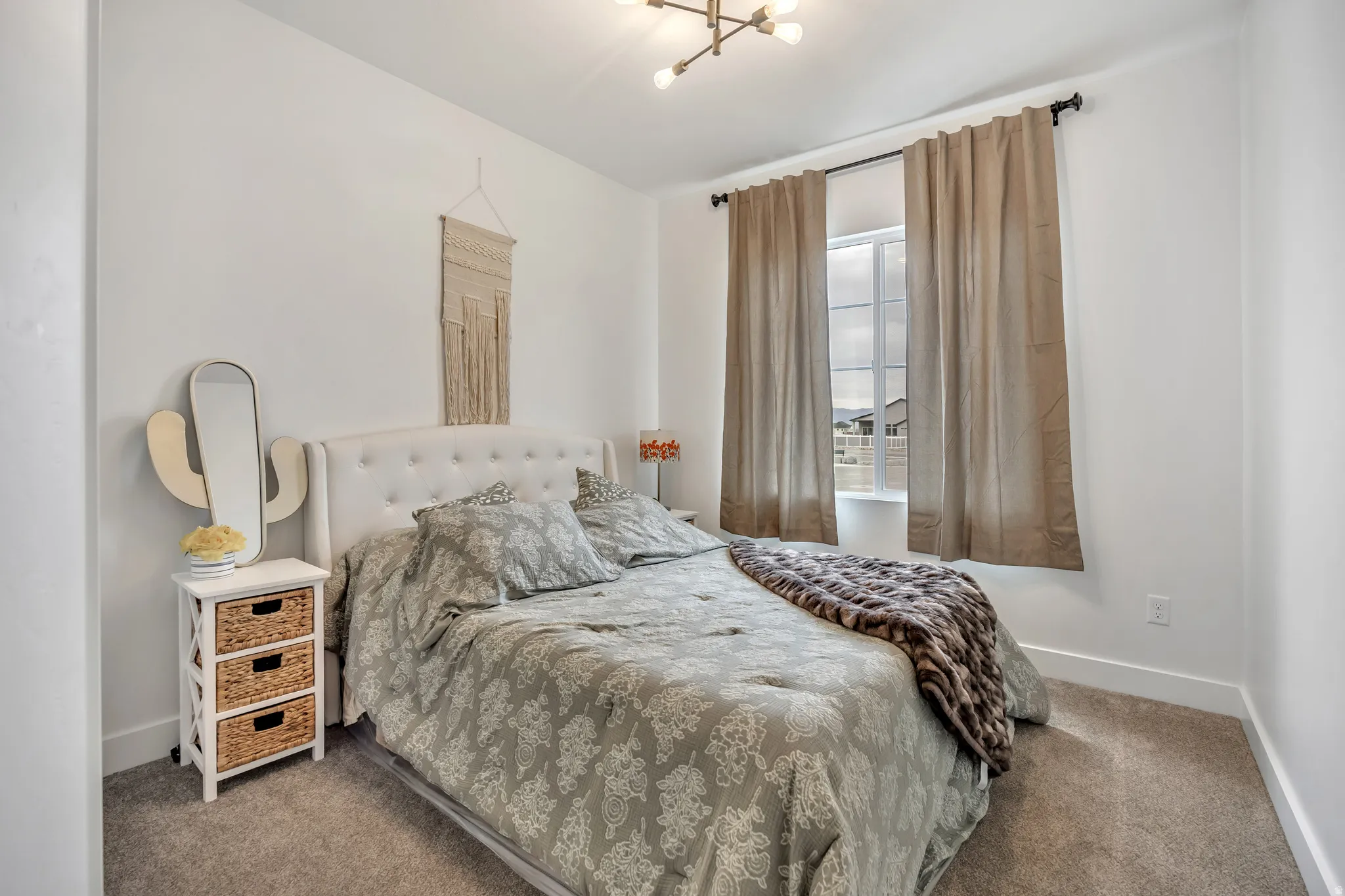 Carpeted bedroom featuring baseboards and a chandelier