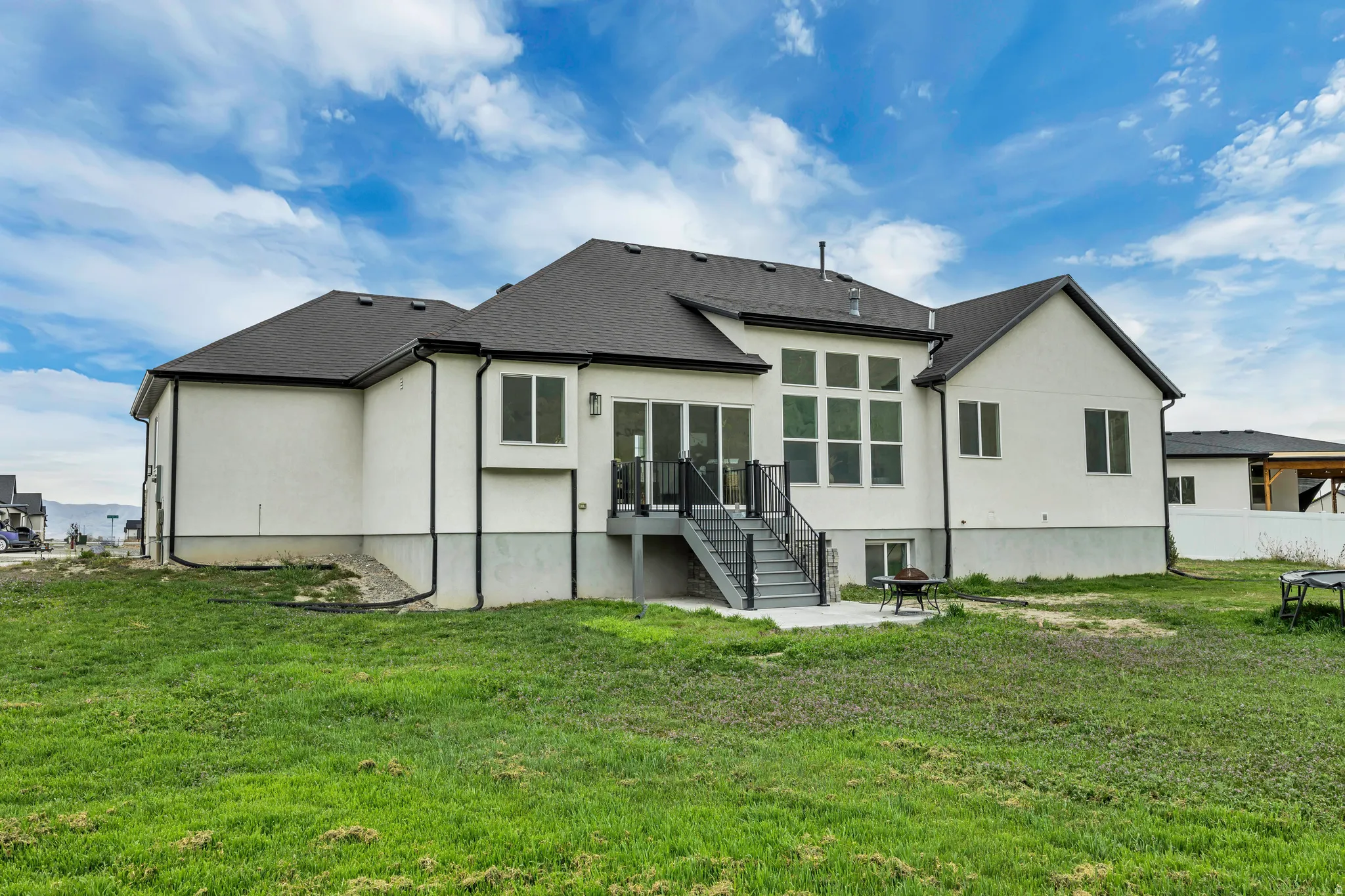 Rear view of property featuring a patio area, stucco siding, and roof with shingles