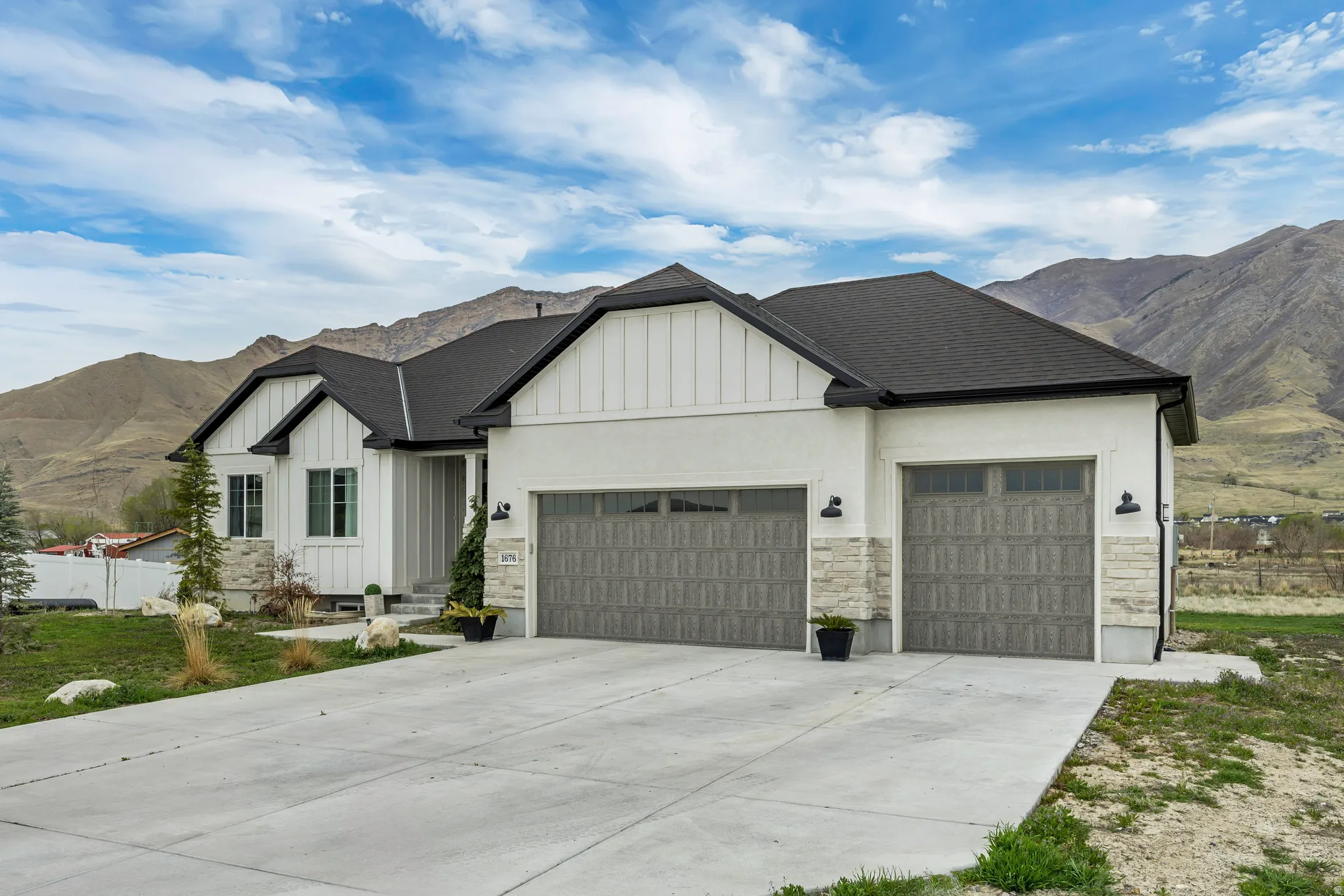 View of front of house featuring a mountain view, board and batten siding, a garage, and driveway