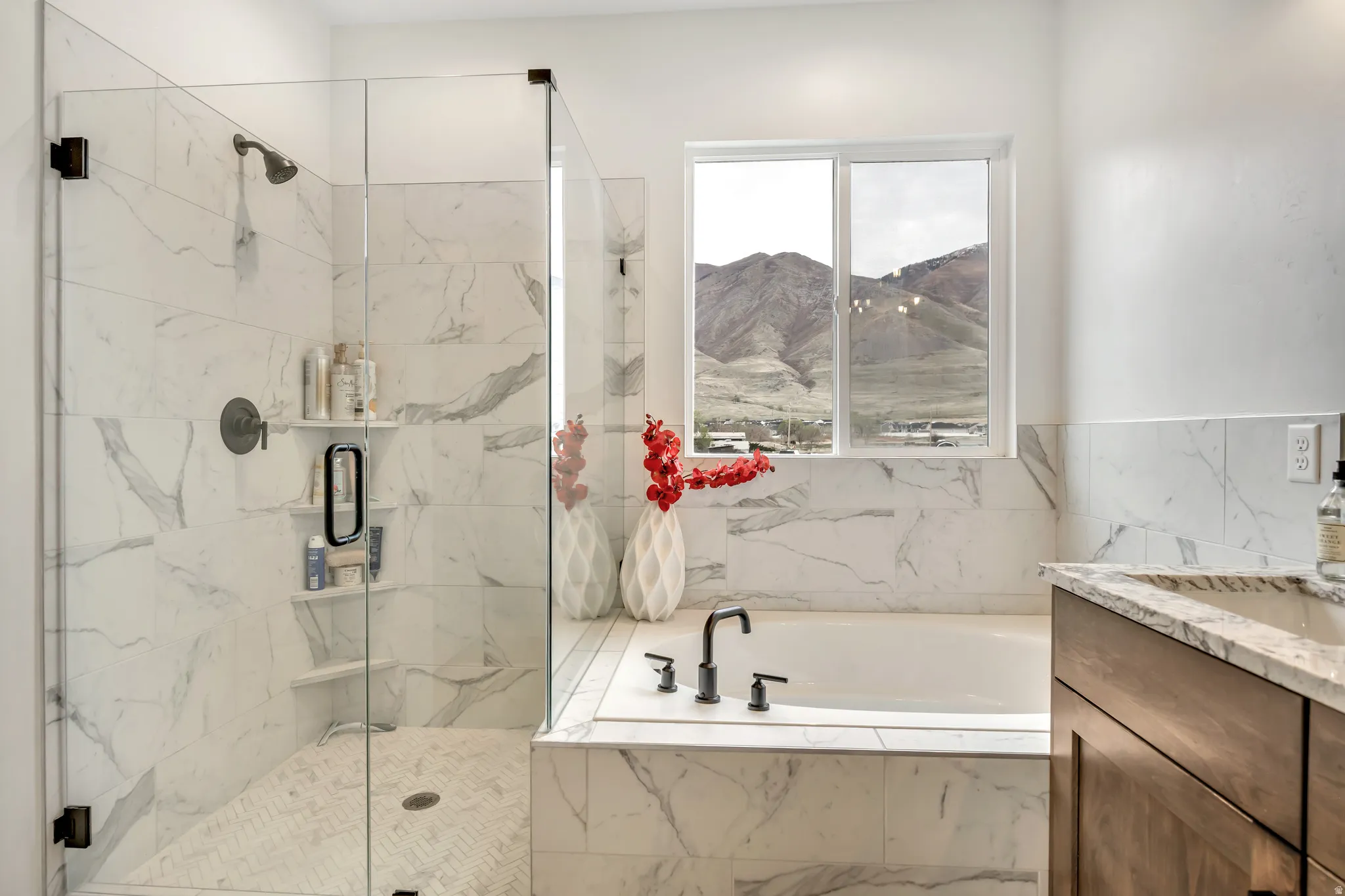Bathroom with vanity, a bath, and a marble finish shower