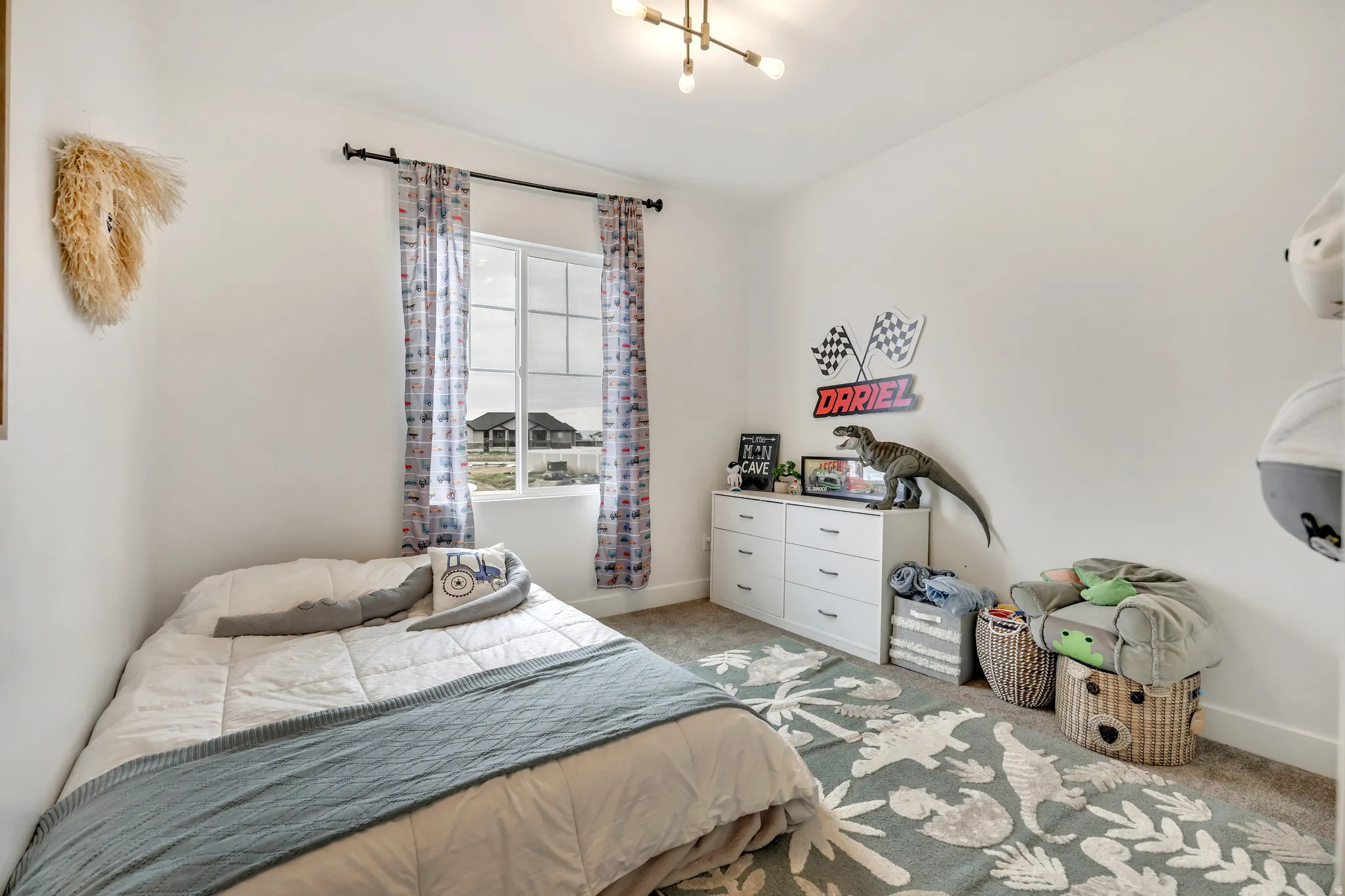 Bedroom with light colored carpet and a chandelier
