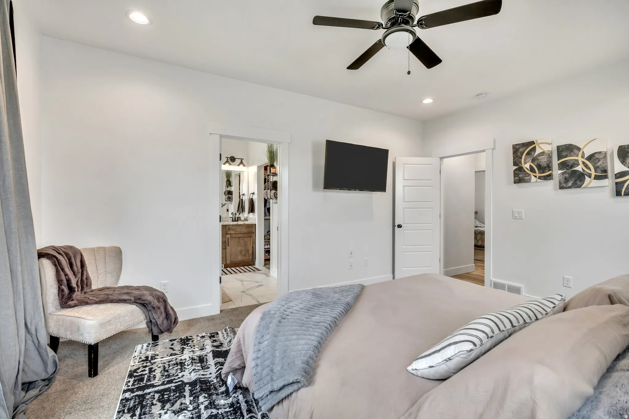 Bedroom with recessed lighting, light carpet, a ceiling fan, and ensuite bath