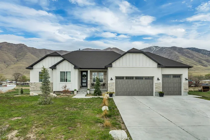 Modern farmhouse style home with board and batten siding, a mountain view, and an attached garage