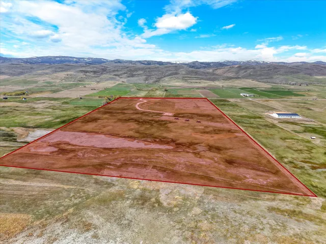 Aerial view of sparsely populated area featuring a mountain backdrop and property parcel outlined