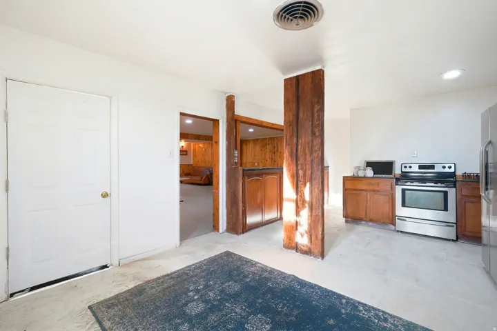 Kitchen featuring stainless steel appliances, wood finish cabinets, concrete floors, and recessed lighting