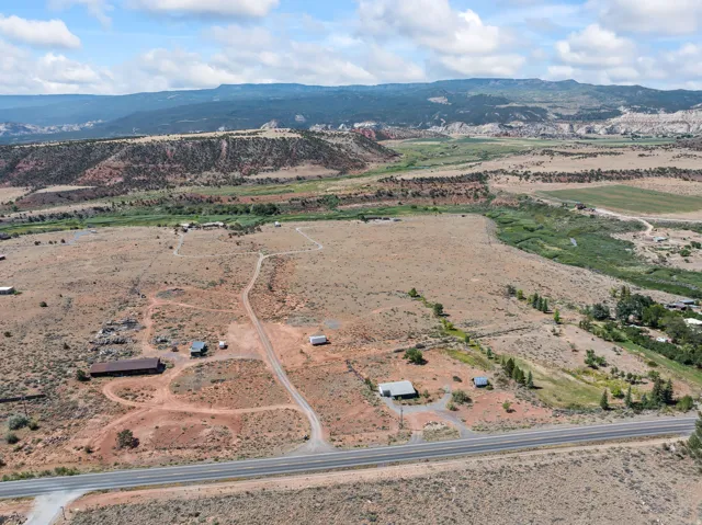 Aerial overview of property's location featuring a mountainous background and rural landscape