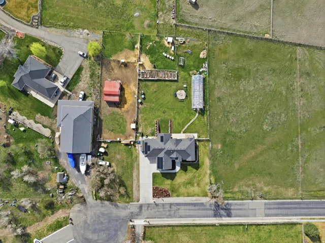 Aerial view of property and surrounding area with nearby suburban area