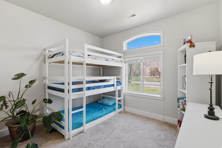 Bedroom featuring light carpet and baseboards