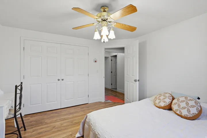 Bedroom with light wood-style flooring, a ceiling fan, and a closet