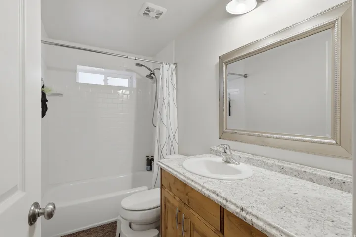 Bathroom featuring vanity and shower / tub combo with curtain