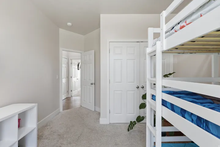 Bedroom with light carpet and a closet