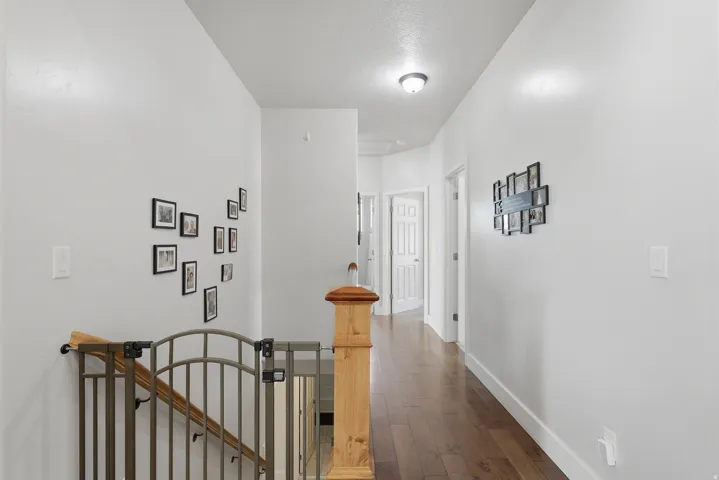 Hall with an upstairs landing and dark wood-type flooring
