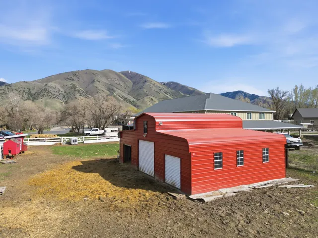 View of property exterior with a mountain view, an outbuilding, and a detached garage
