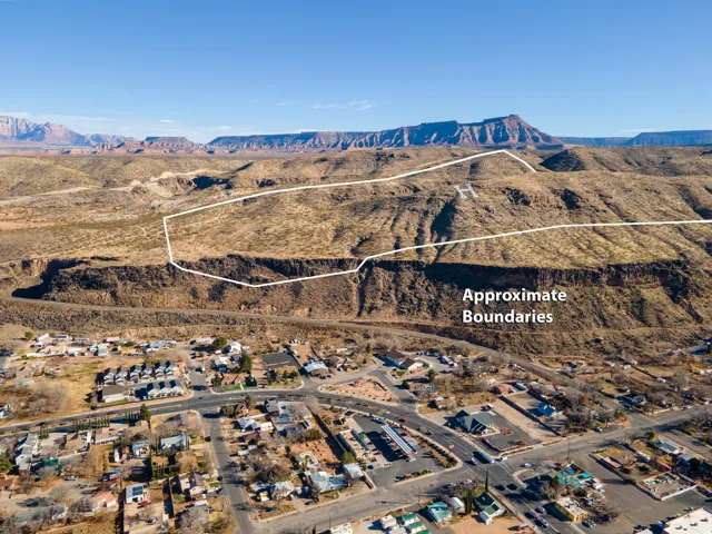 Aerial perspective of suburban area with a mountain backdrop and property parcel outlined