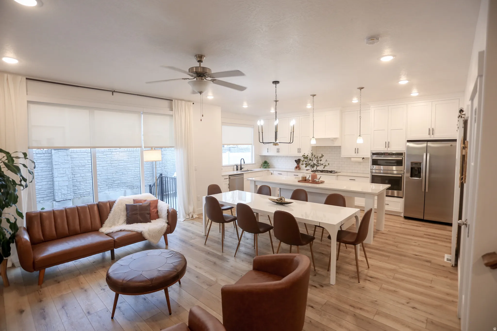 Dining space featuring light wood-type flooring, ceiling fan, and hanging lights