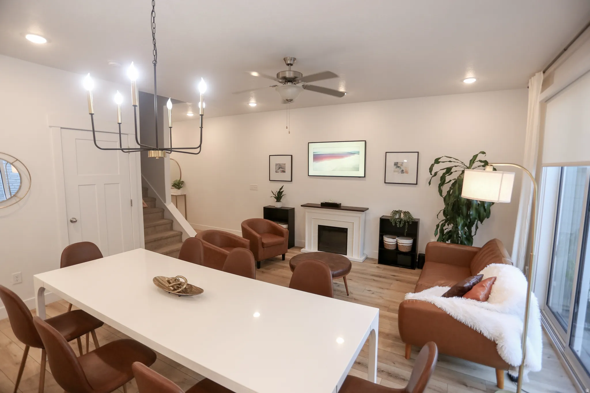 Dining area with light wood finished floors, ceiling fan, recessed lighting, and a fireplace