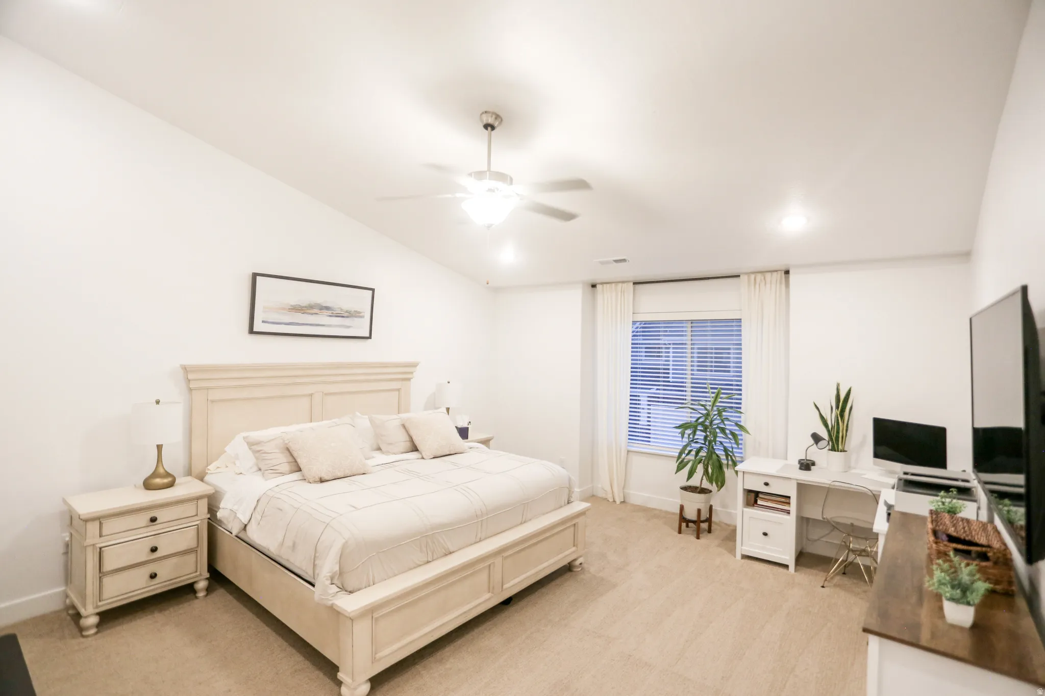 Bedroom featuring a desk, a ceiling fan, light carpet, and vaulted ceiling