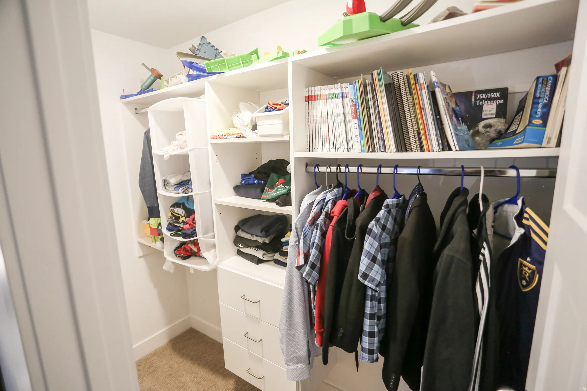 Walk in closet featuring light colored carpet