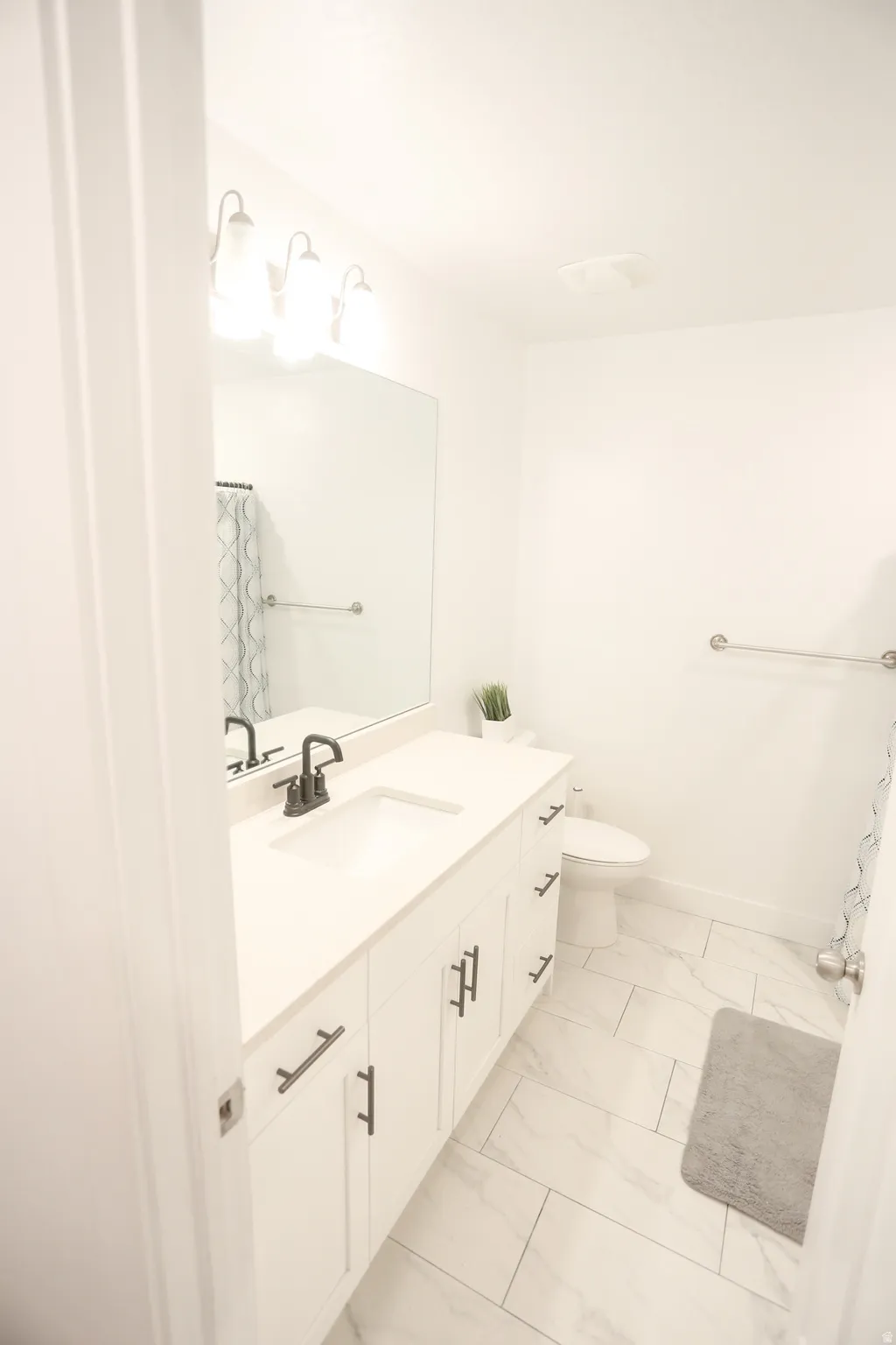 Full bathroom featuring a shower with curtain, vanity, and light marble finish floors
