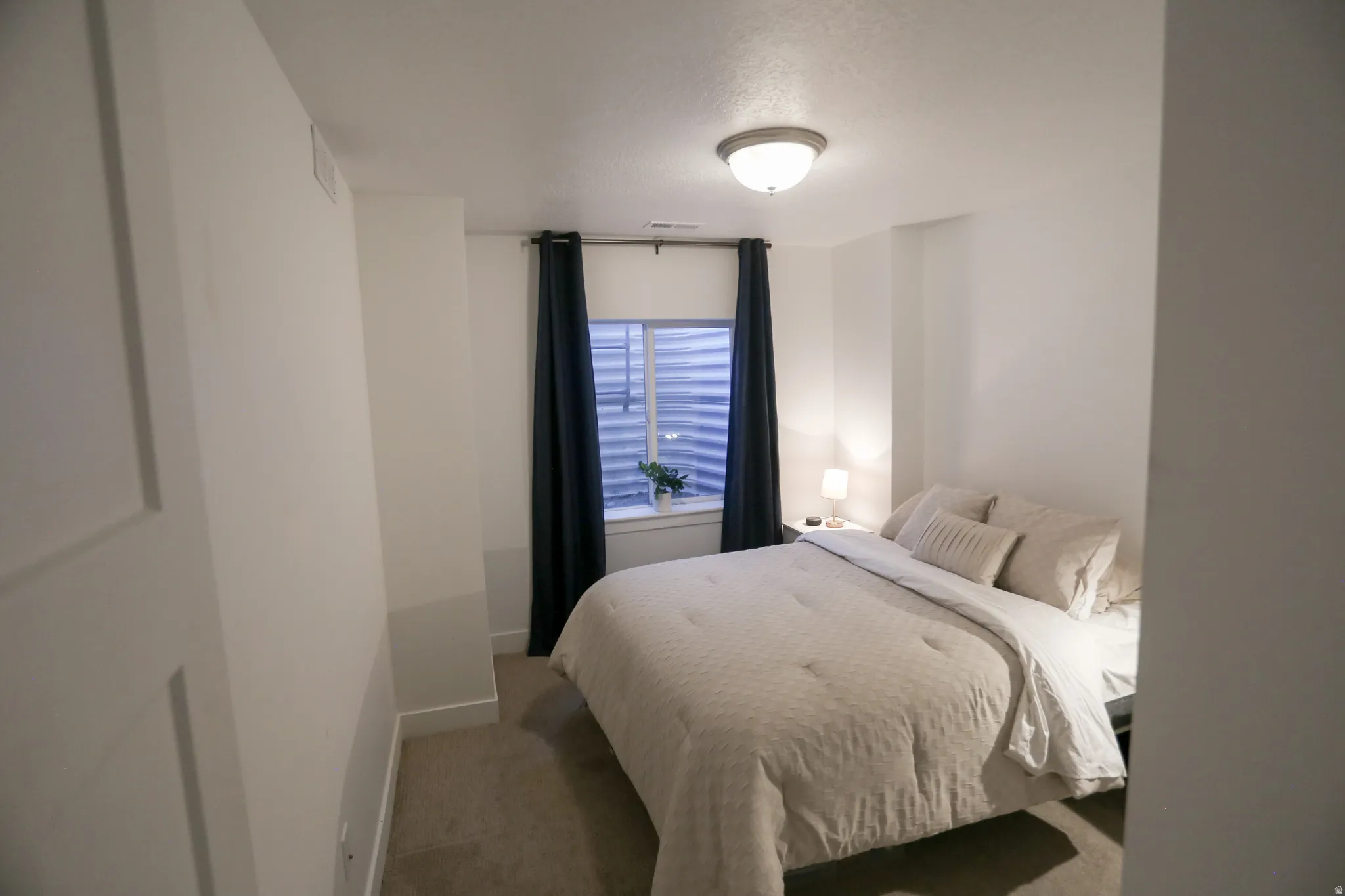 Bedroom with carpet and a textured ceiling