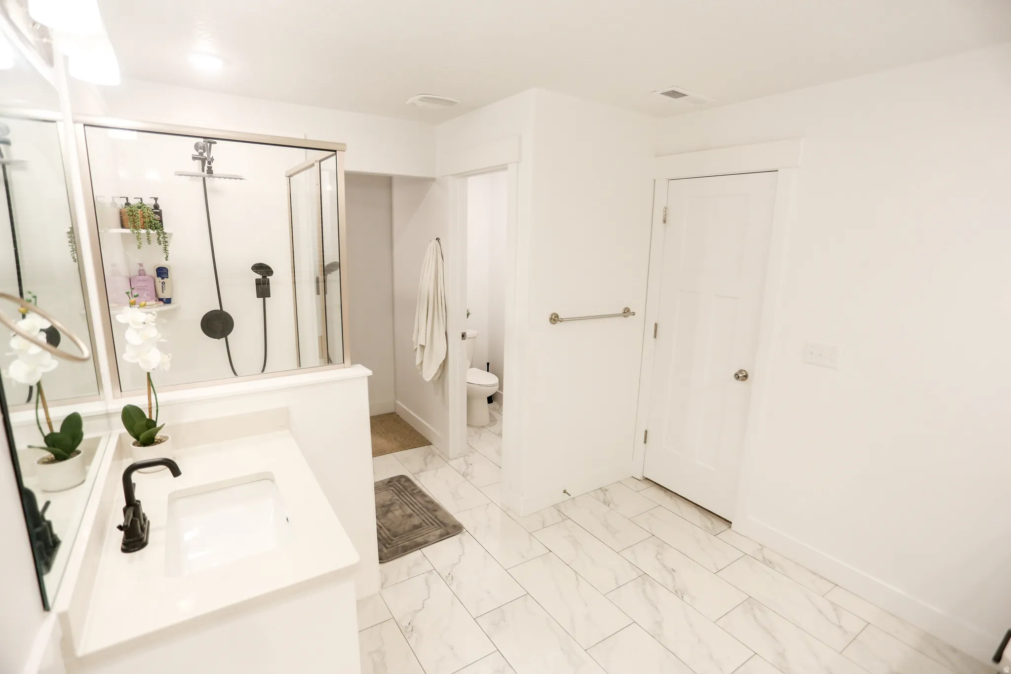 Full bathroom with vanity, a stall shower, and light marble finish flooring