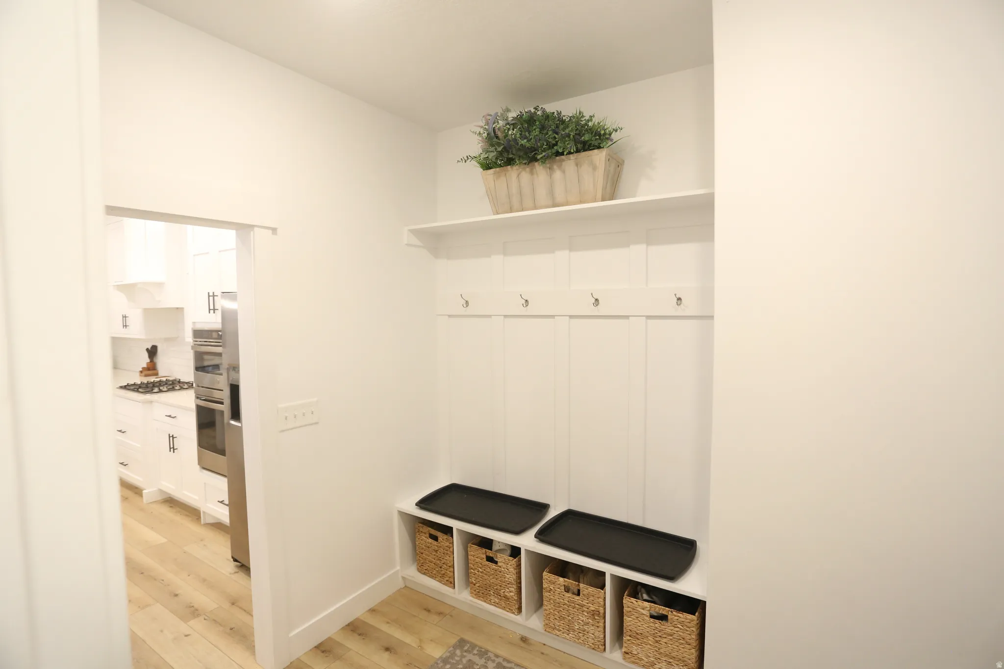 Mudroom featuring light wood-style floors and baseboards