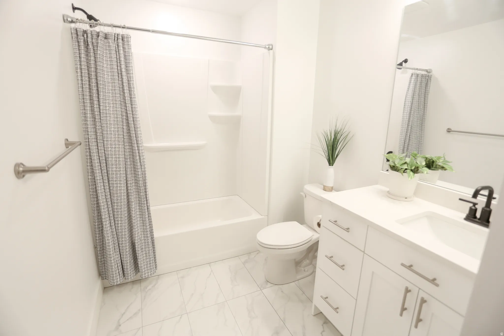 Bathroom featuring vanity, shower / bath combination with curtain, and light marble finish flooring