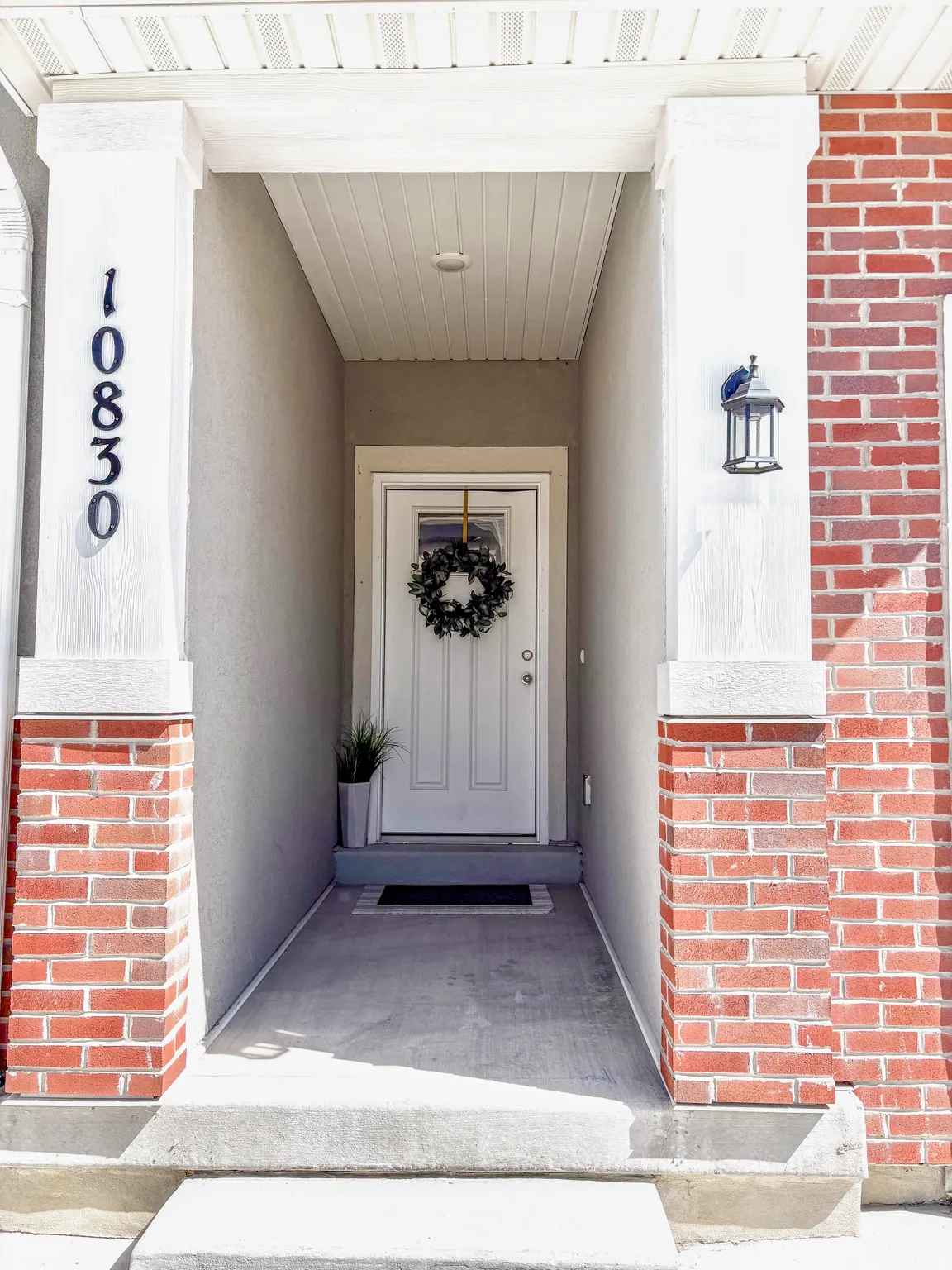 Doorway to property with brick siding and stucco siding
