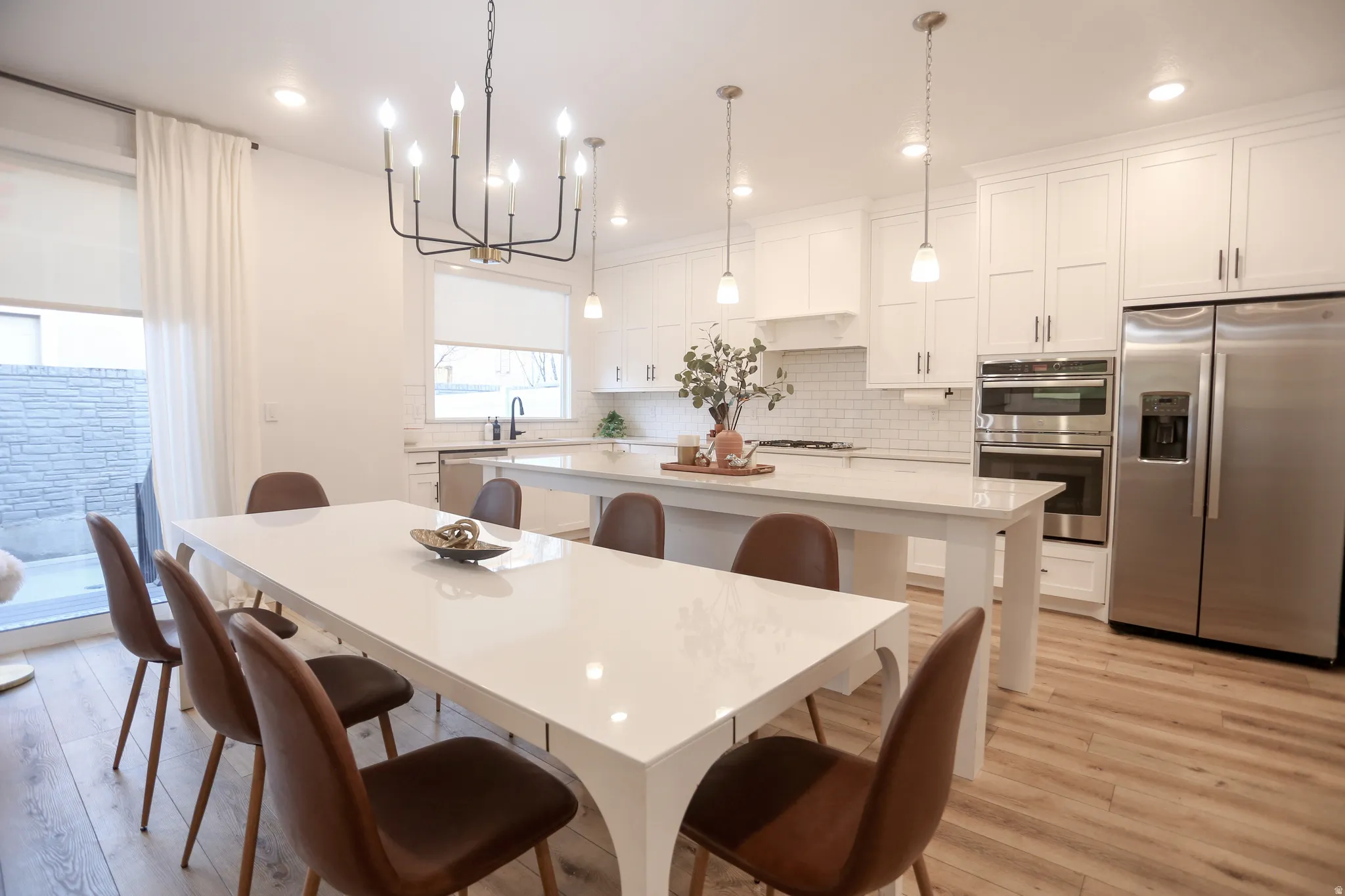 Dining space with hanging lights and light wood-style floors