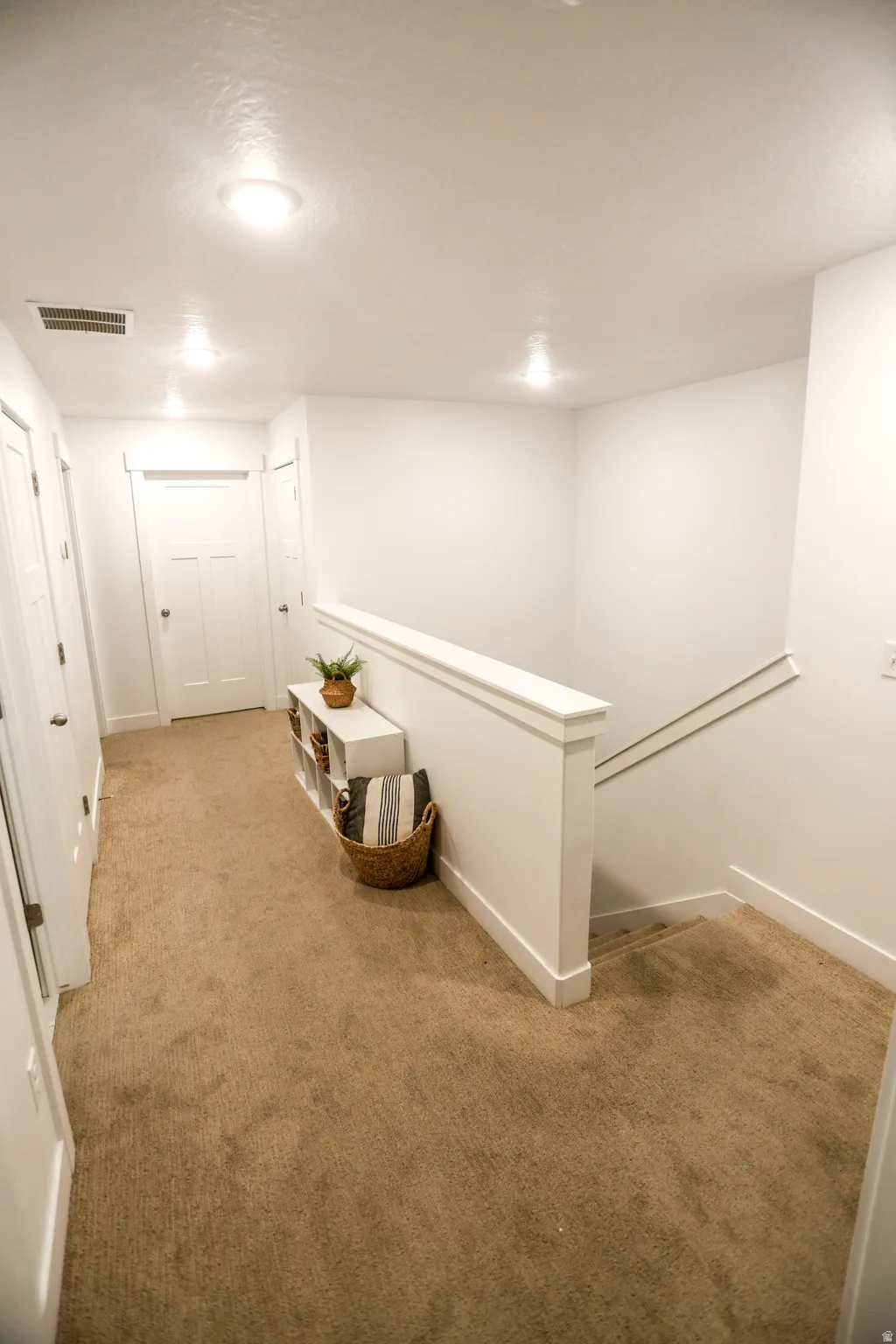 Corridor with light carpet and an upstairs landing