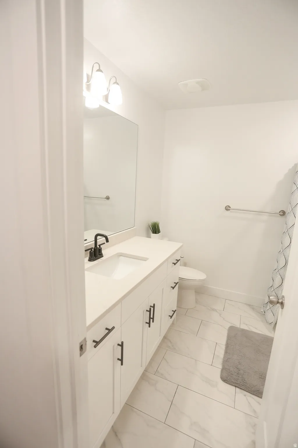 Bathroom with vanity and light marble finish flooring