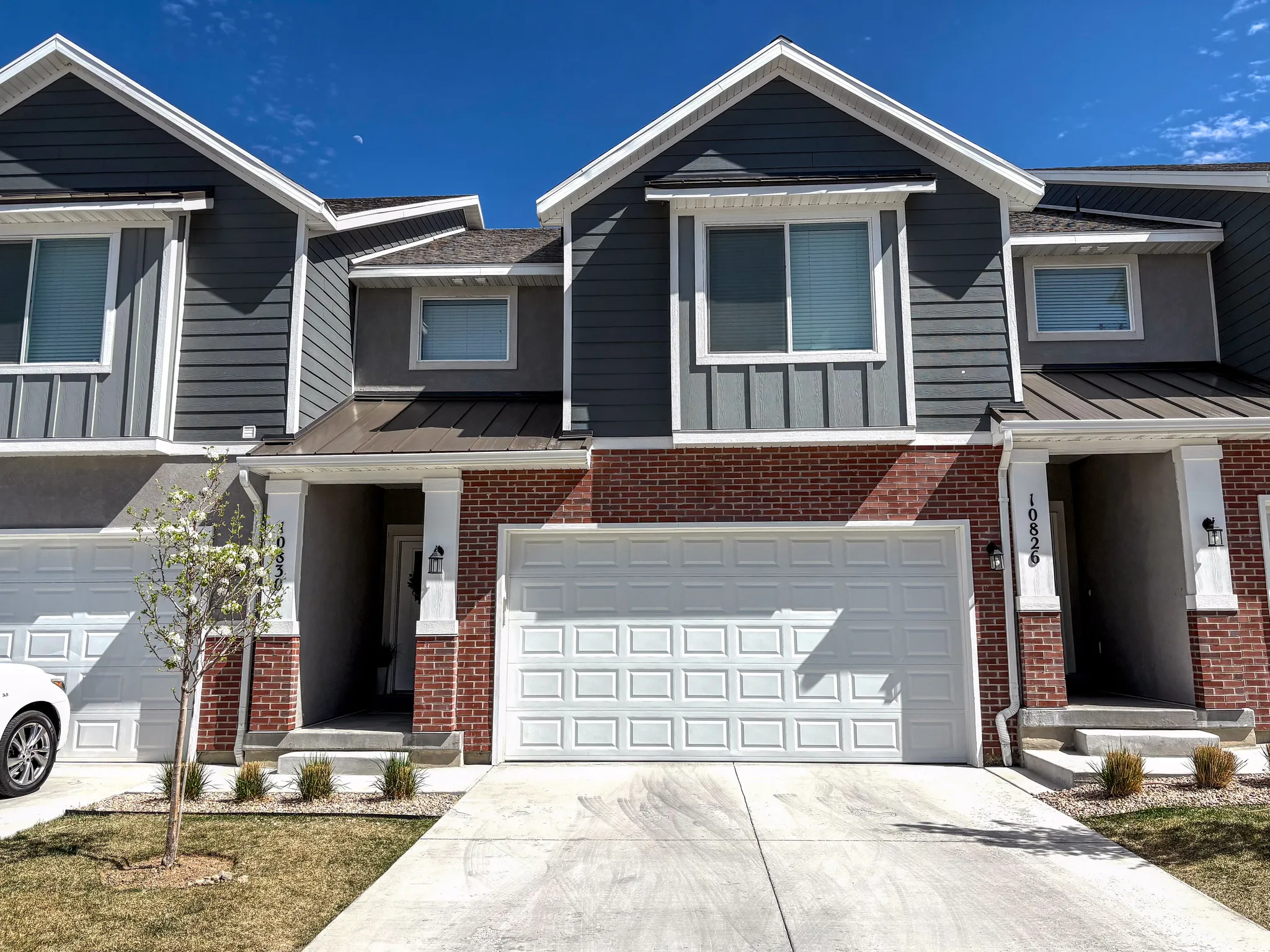 View of front of property featuring brick siding, driveway, and an attached garage
