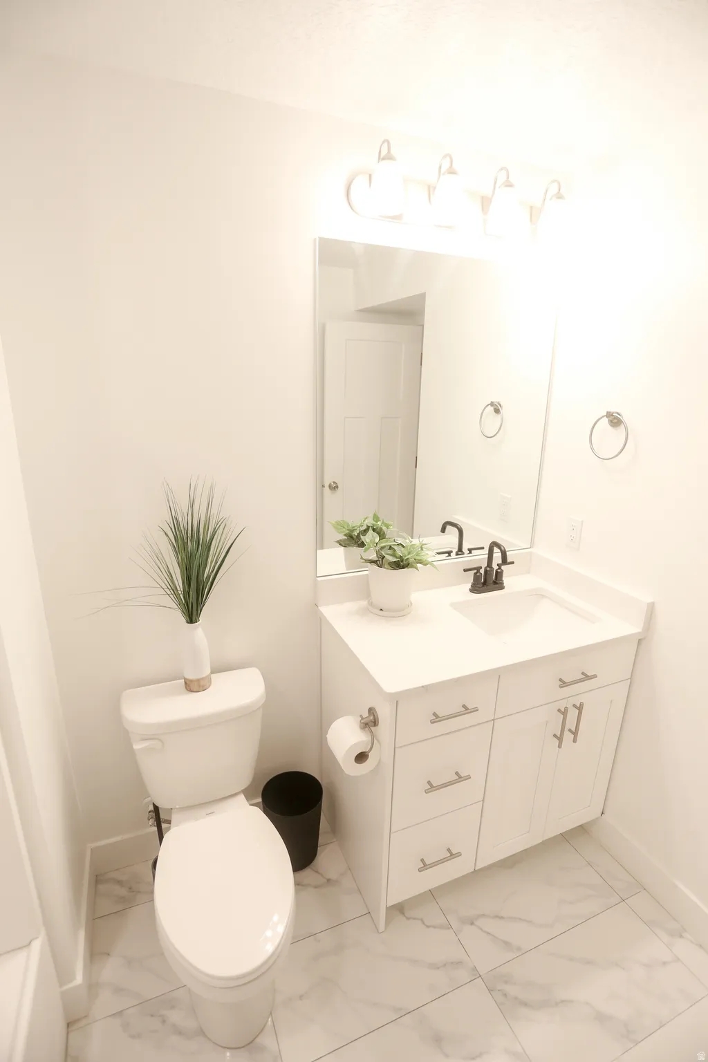 Bathroom featuring vanity and light marble finish flooring