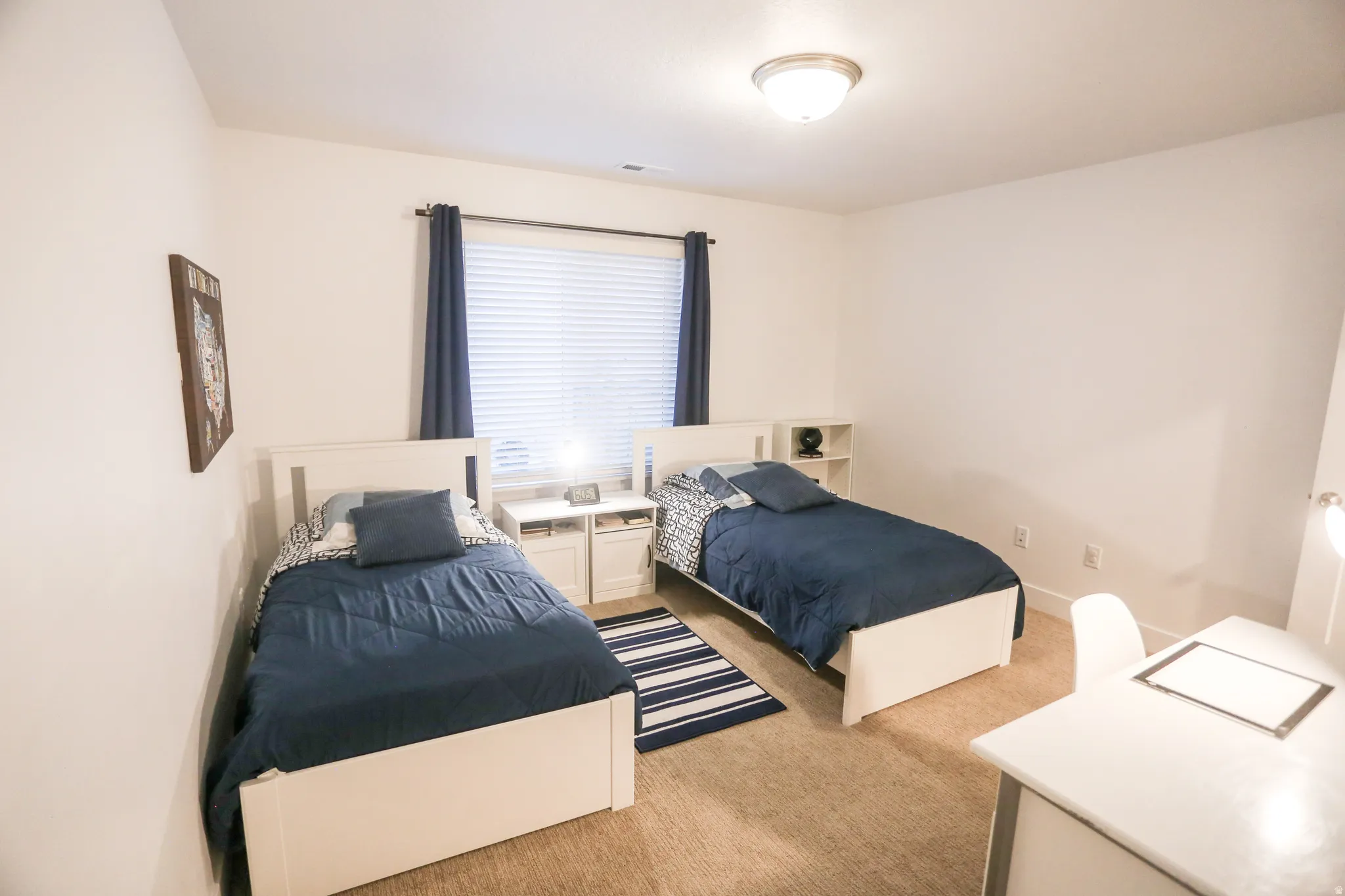Bedroom featuring light carpet and baseboards