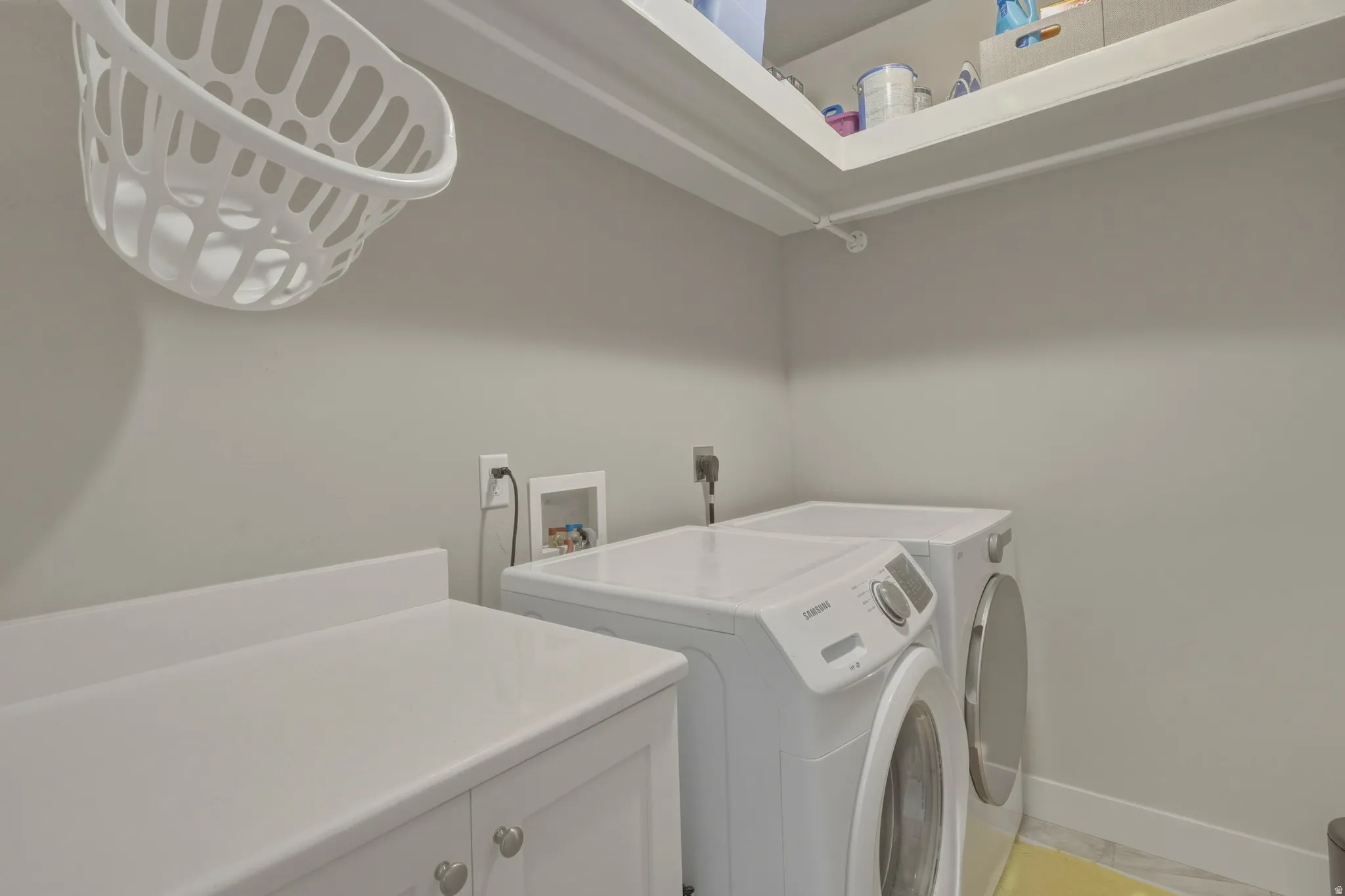 Laundry room featuring washer and dryer and baseboards