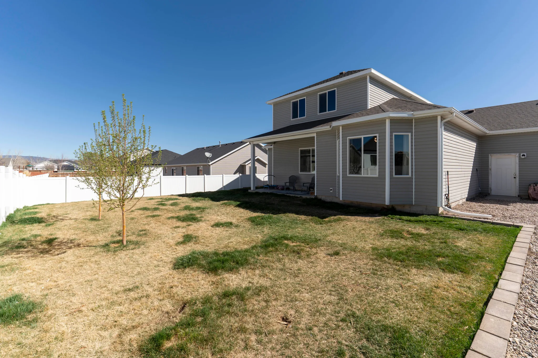 Rear view of house with a patio area, a fenced backyard, and roof with shingles