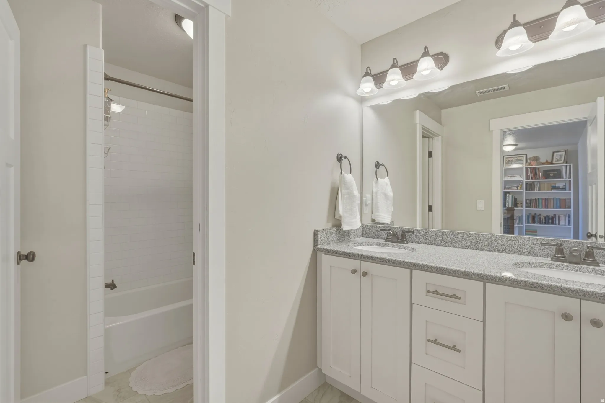 Full bath with double vanity and bathing tub / shower combination