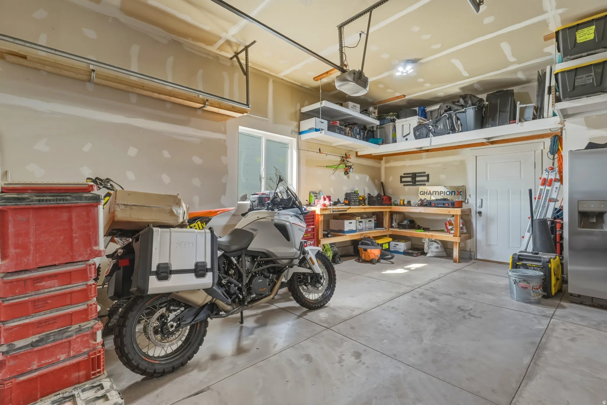 Garage featuring a garage door opener, and a workshop area