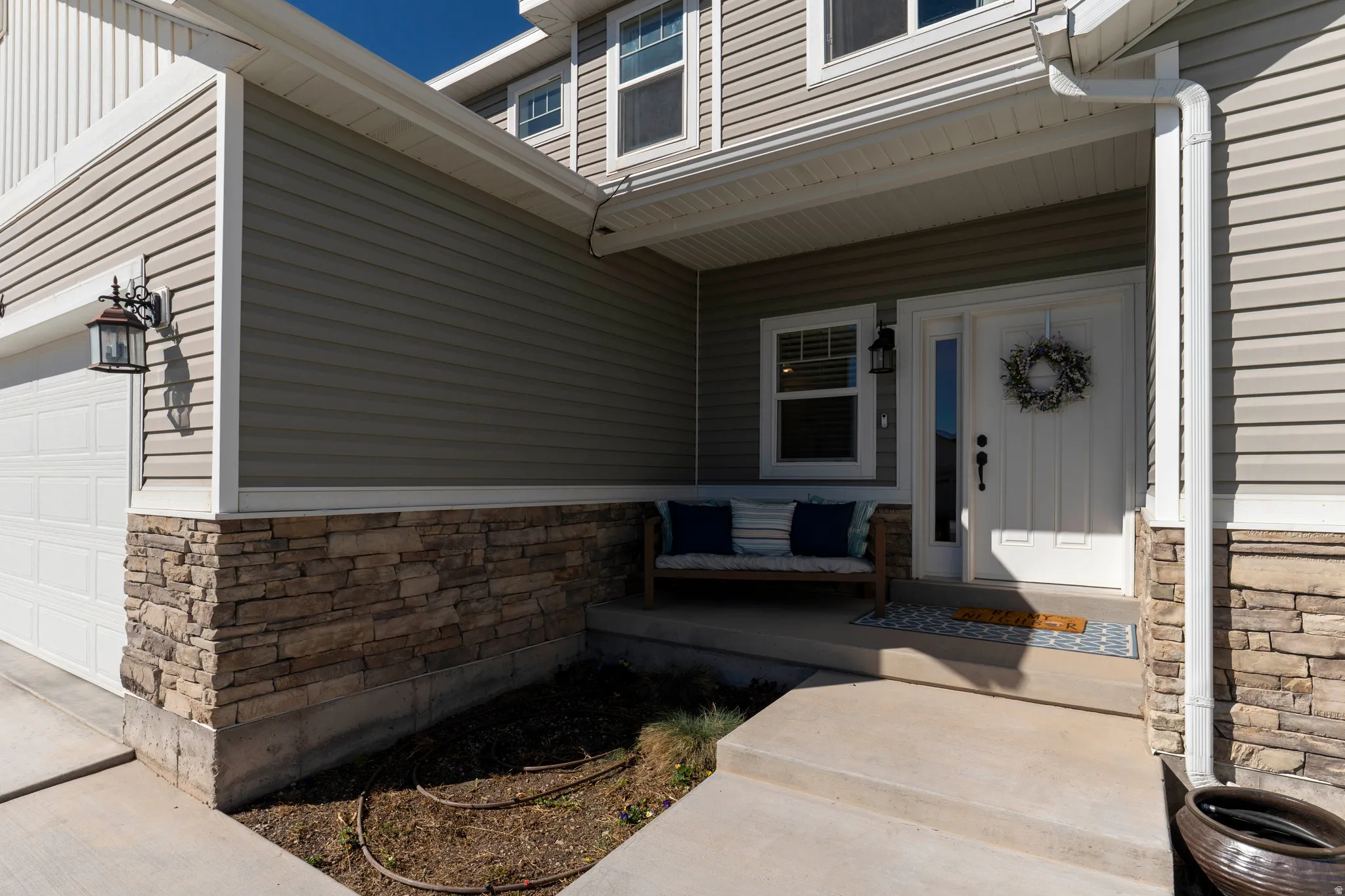 Entrance to property featuring stone siding and covered porch
