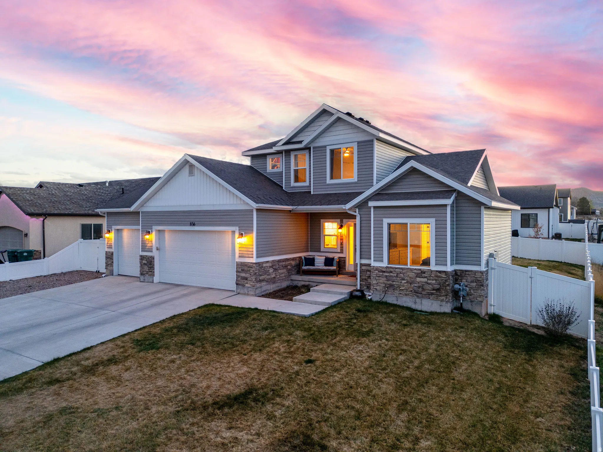Modern two-story residence featuring gray siding and stone accents