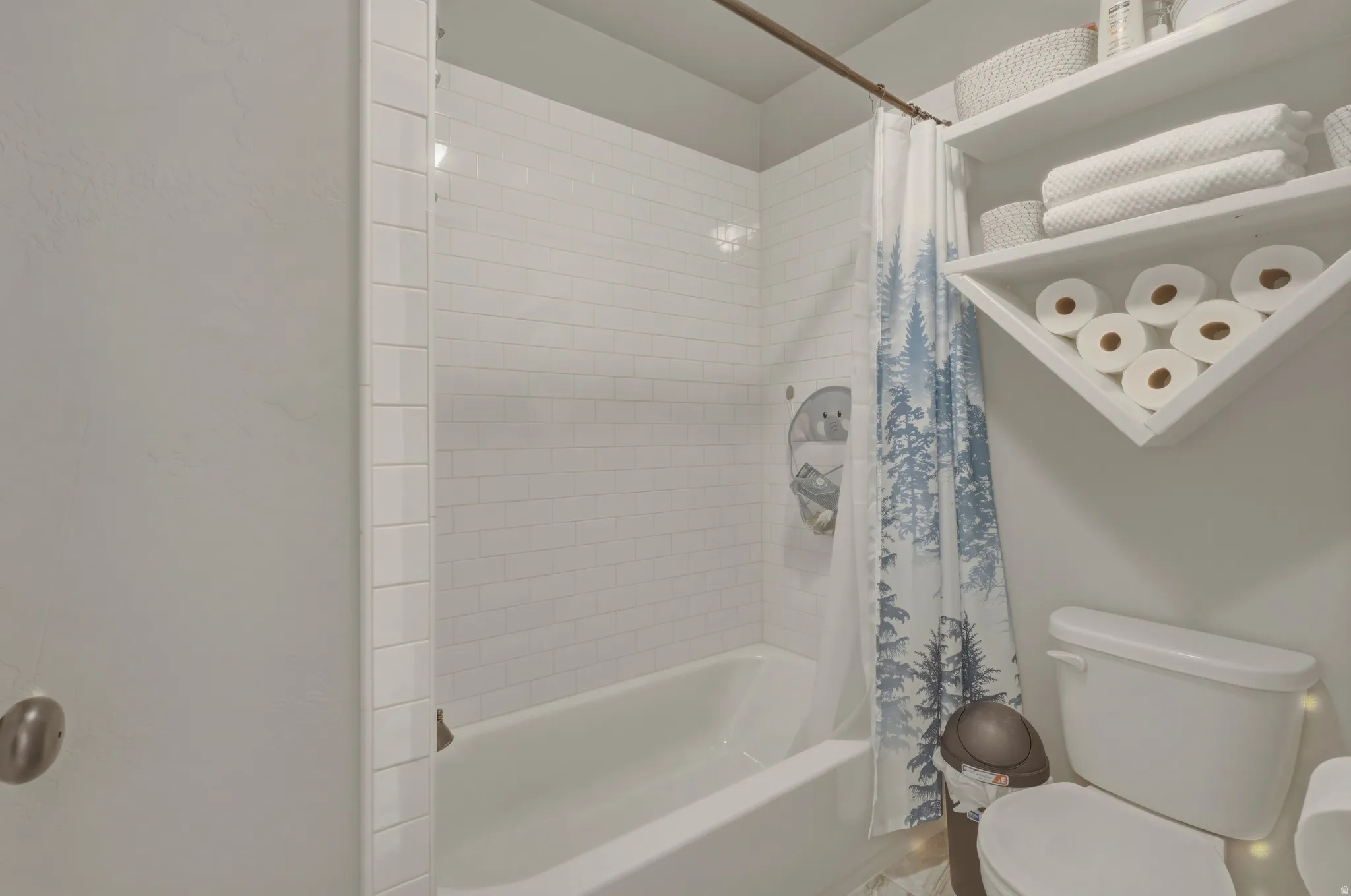 Bathroom with toilet and shower / bath combo with shower curtain